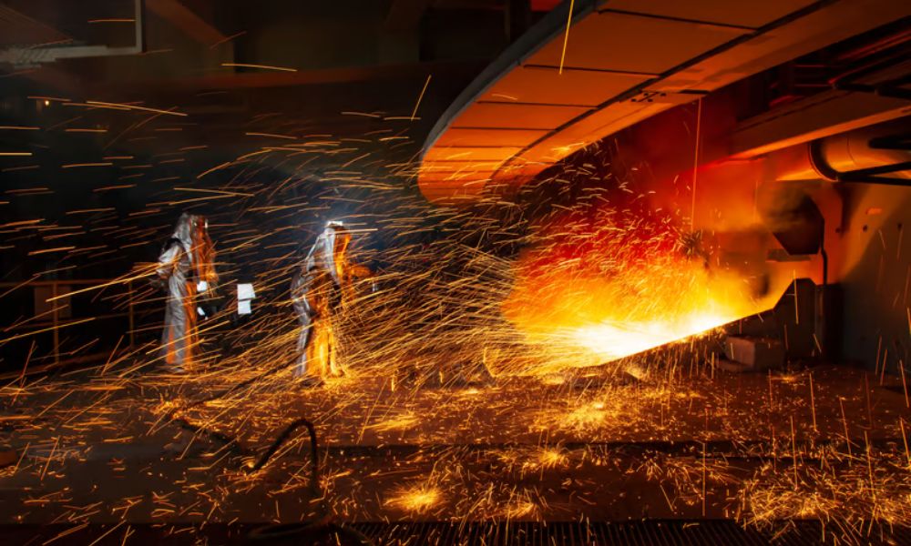 This image represents A Guide to Superalloys in Investment Casting with molten metal pouring, ceramic shell moulds, and nickel-based alloy casting production.